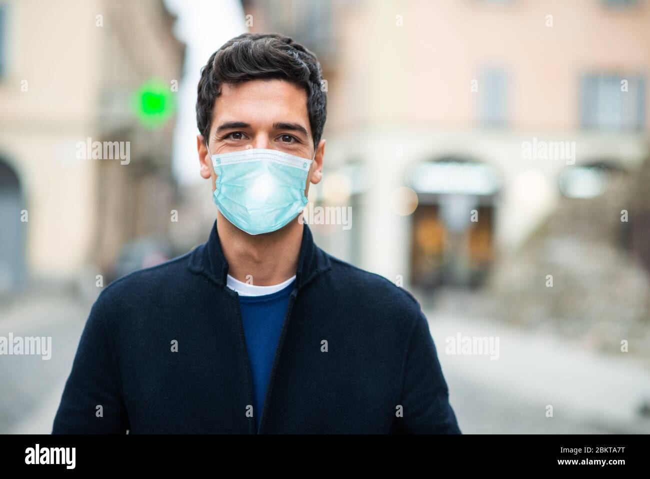 Maskierter Mann, der in einer einsamen Stadt läuft, Coronavirus Pandemie Konzept Stockfoto
