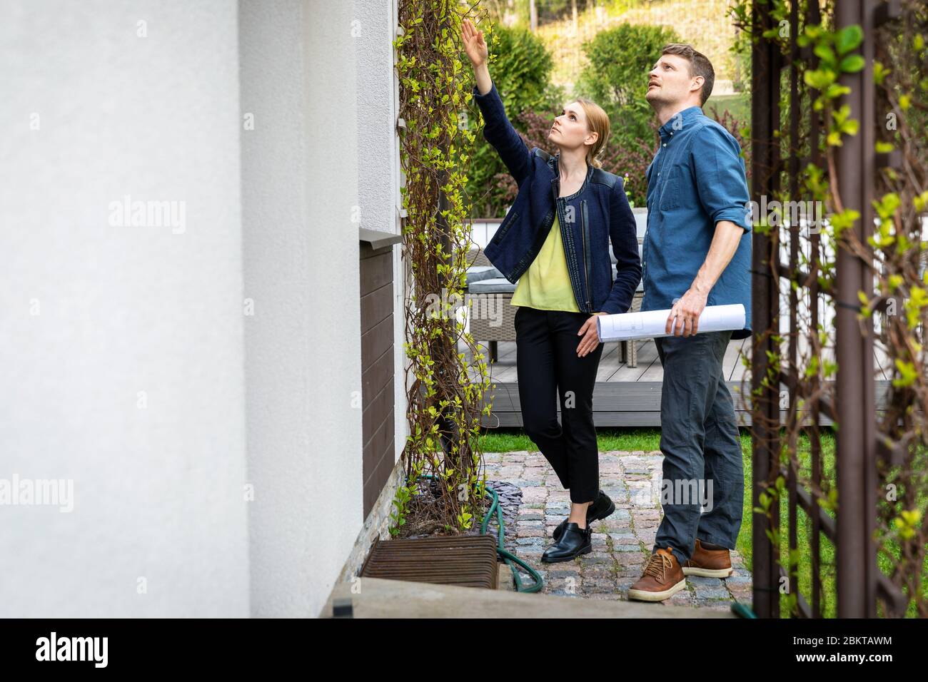 Immobilienmakler präsentiert Haus für Kunden im Freien Stockfoto