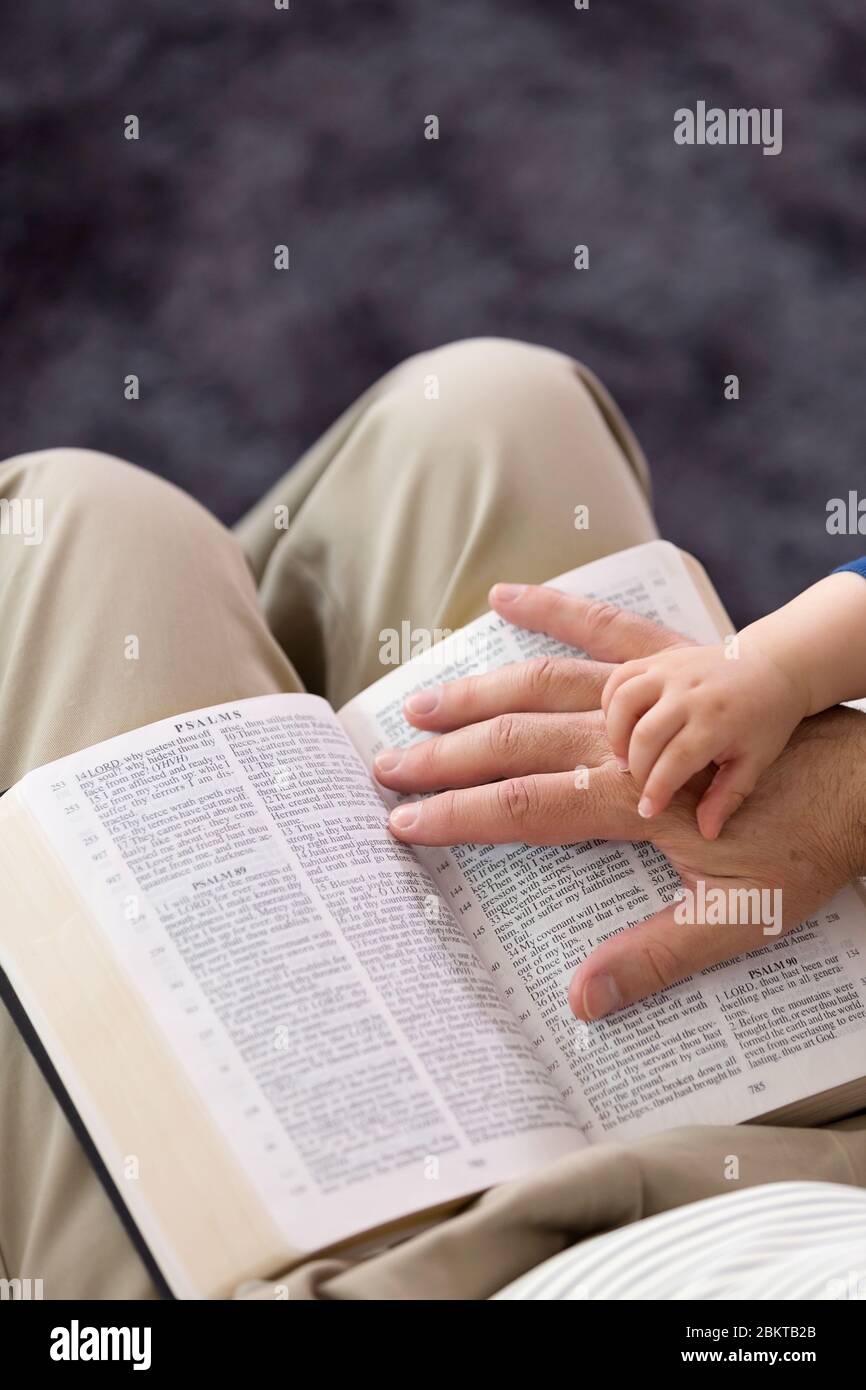 Großvater liest seinem jungen Enkel Geschichten aus der Heiligen Bibel vor Stockfoto
