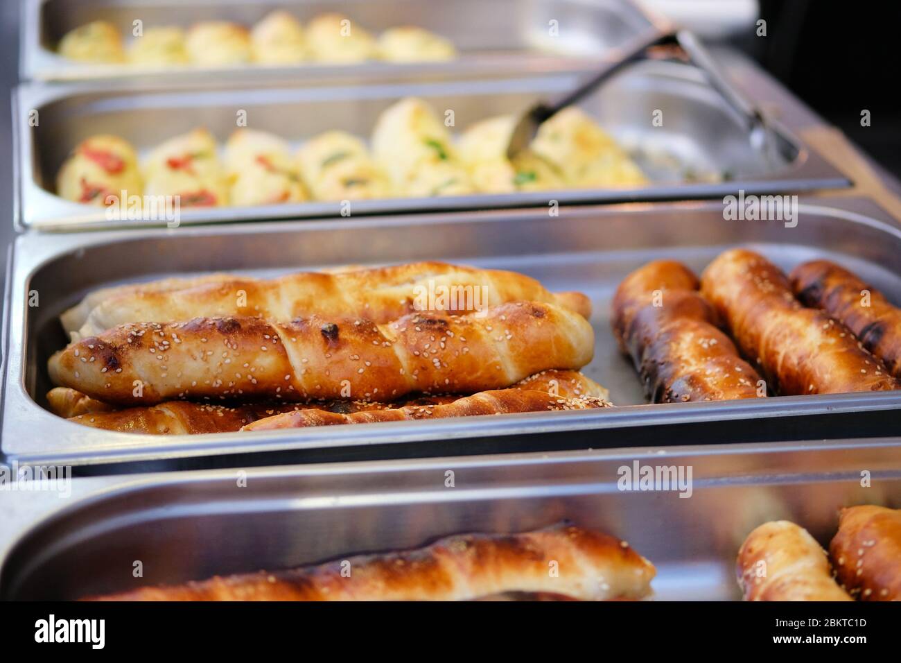 Brotbrötchen mit Sesamsamen in Metallbehältern werden auf appetitlichen Food Festival-Event in der Küche verkauft. Street Food conсept. Stockfoto