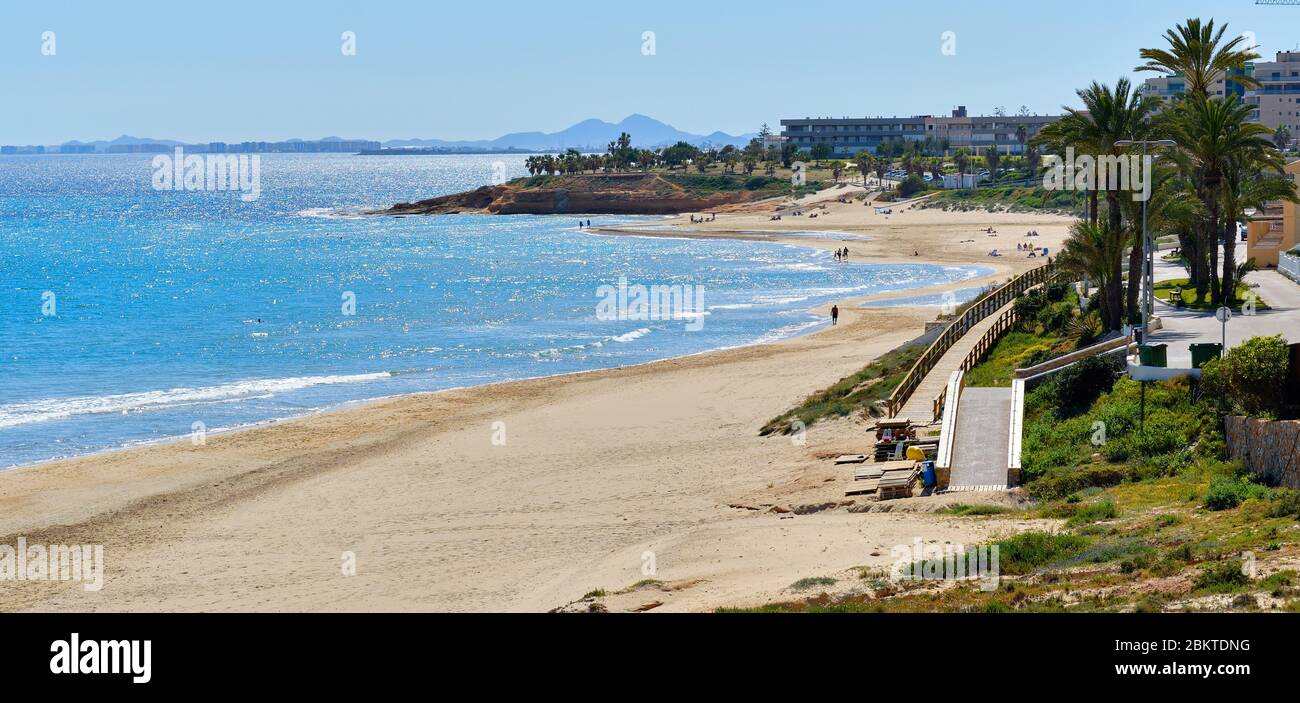 Panoramabild malerische Landschaft idyllische Landschaft Blick, Menschen genießen warmes Wetter zu Fuß auf Mil Palmeras spanischen Costa Blanca Strand Stockfoto