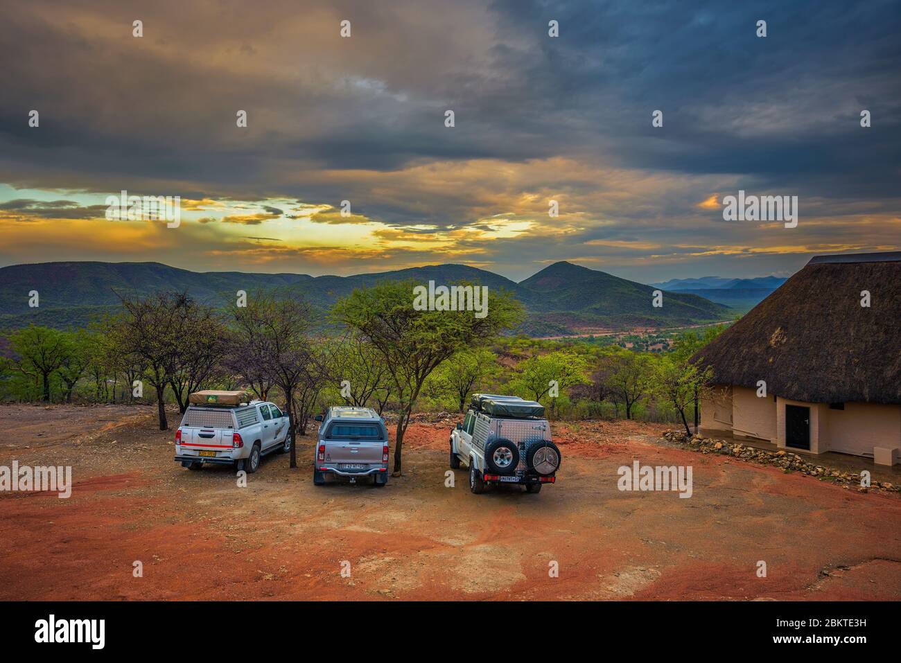 SUV-Autos auf einem touristischen Campingplatz in Namibia bei Sonnenuntergang geparkt Stockfoto