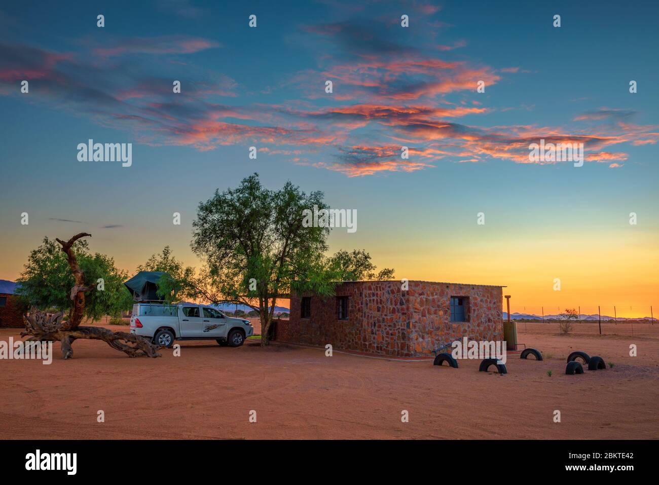 Sonnenuntergang in einem Wüstencamp in Namibia mit einem Pickup 4x4 Auto mit Dachzelt Stockfoto