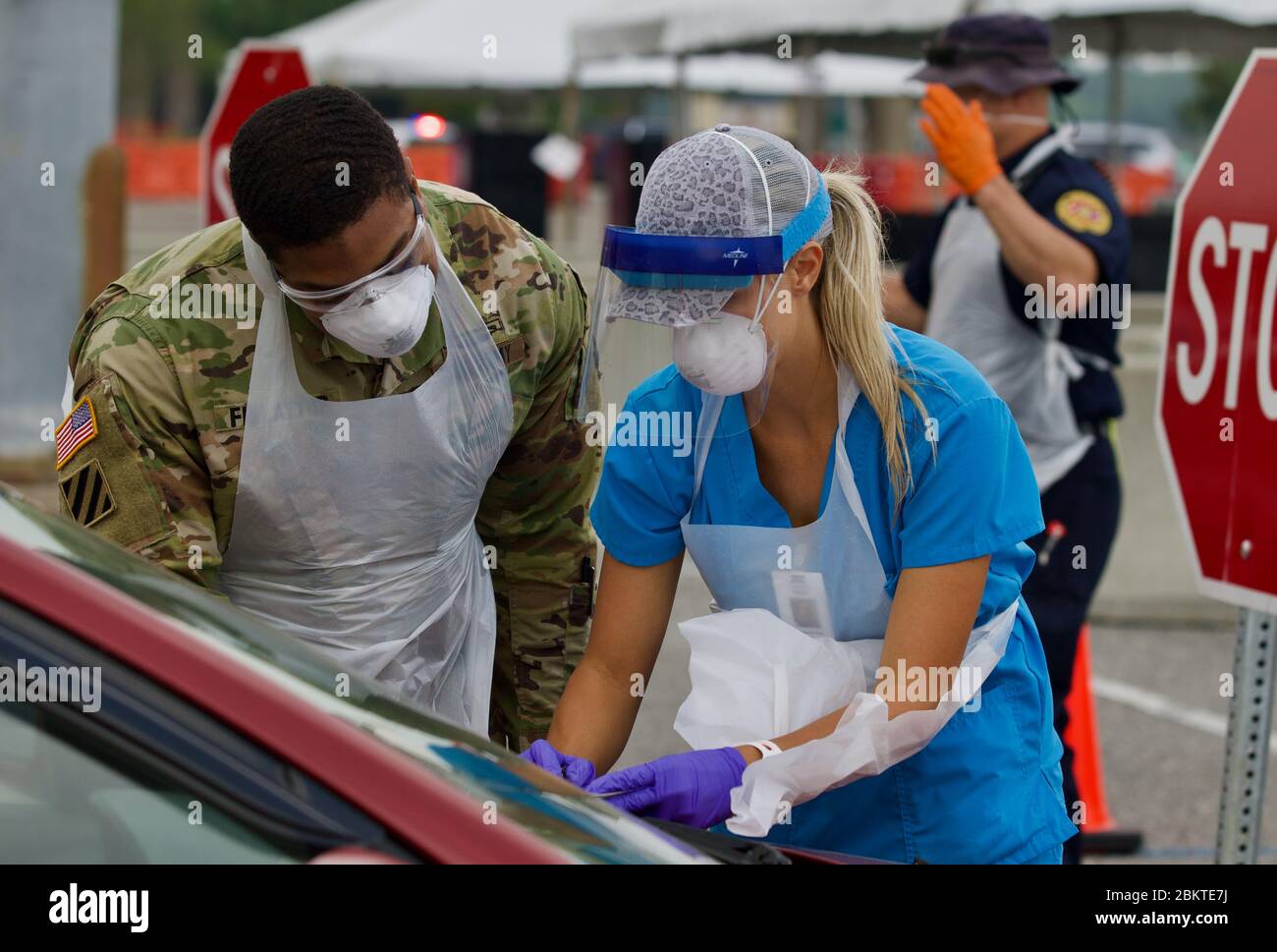 Soldaten der Florida National Guard und eine zivile Krankenschwester unterstützen ein COVID-19 Coronavirus Drive Thru Testzentrum im TIAA Bank Field 13. April 2020 in Jacksonville, Florida. Stockfoto