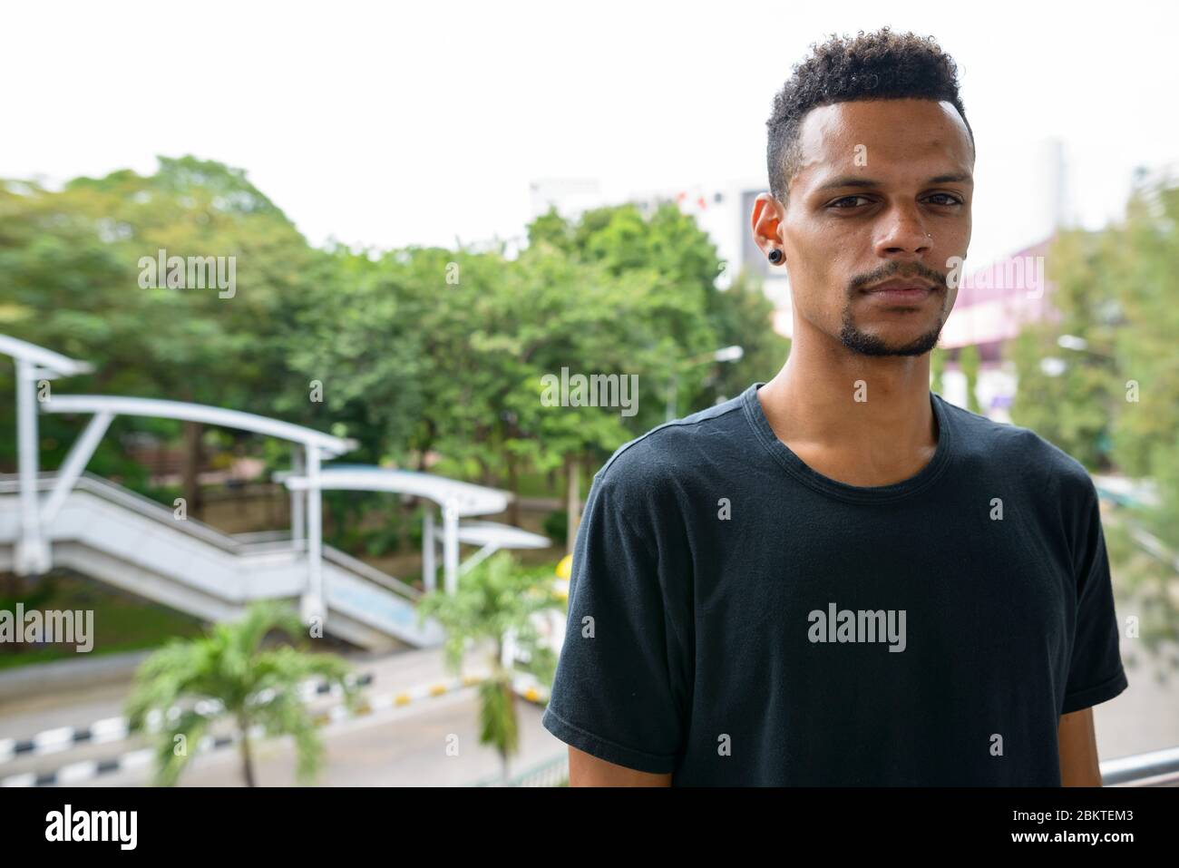 Junger schöner bärtiger Afrikaner in der Stadt draußen Stockfoto