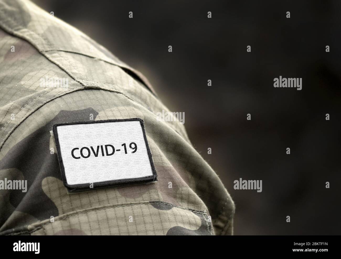 COVID-19 Zeichen auf Militäruniform. COVID-19-Konzept. Coronavirus Kriegskonzept. Weltweite Pandemie. Stockfoto