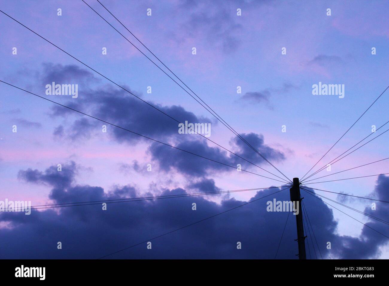 Violetter Sonnenuntergang hinter Telefonleitungen in Manchester, England Stockfoto
