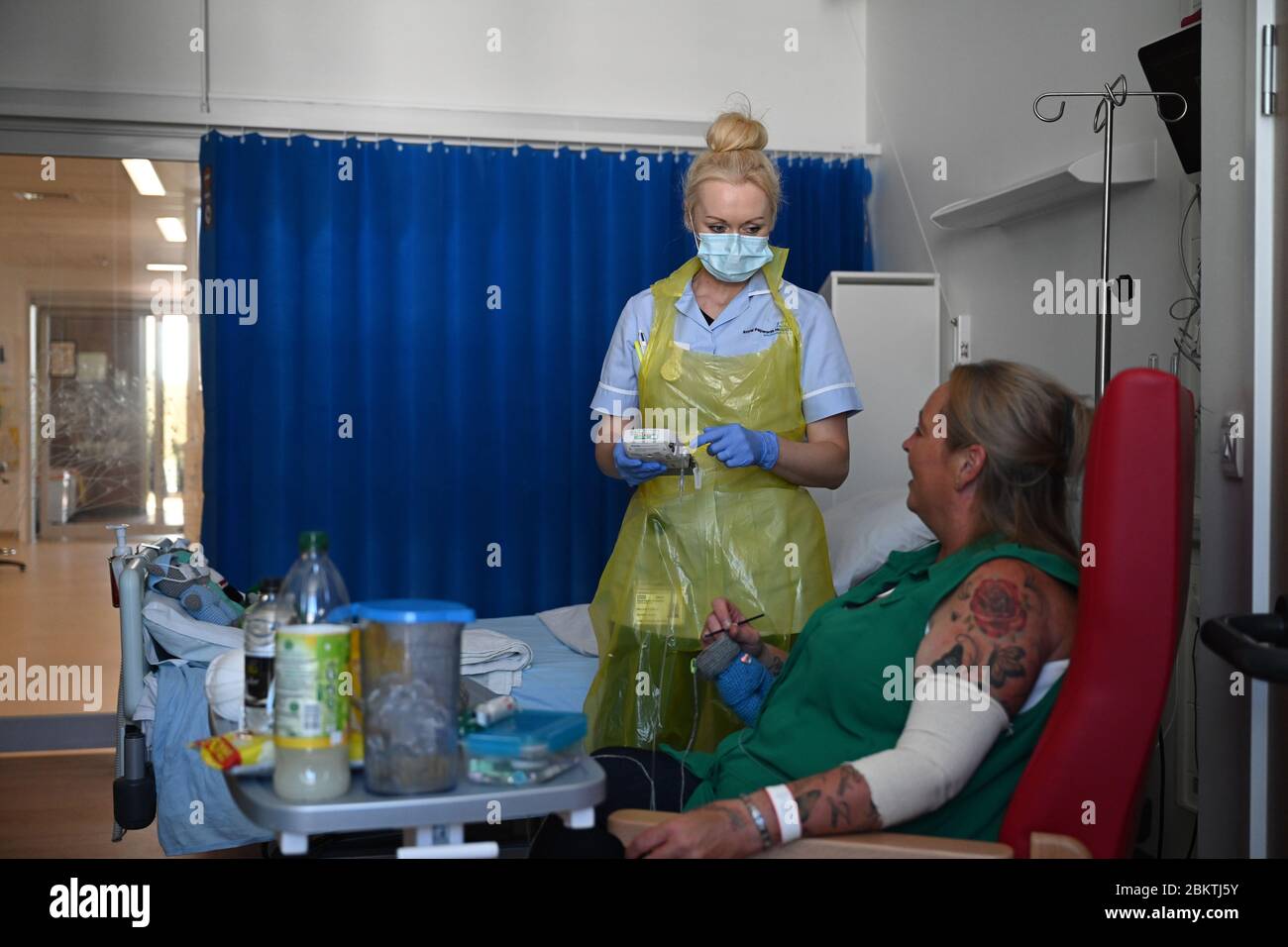 Eine Mitarbeiterin des klinischen Personals trägt persönliche Schutzausrüstung (PSA), während sie den Patienten Trudy Woodfall betreut, der sich auf der Covid Recovery Station im Royal Papworth Hospital in Cambridge vom Coronavirus erholt. Stockfoto