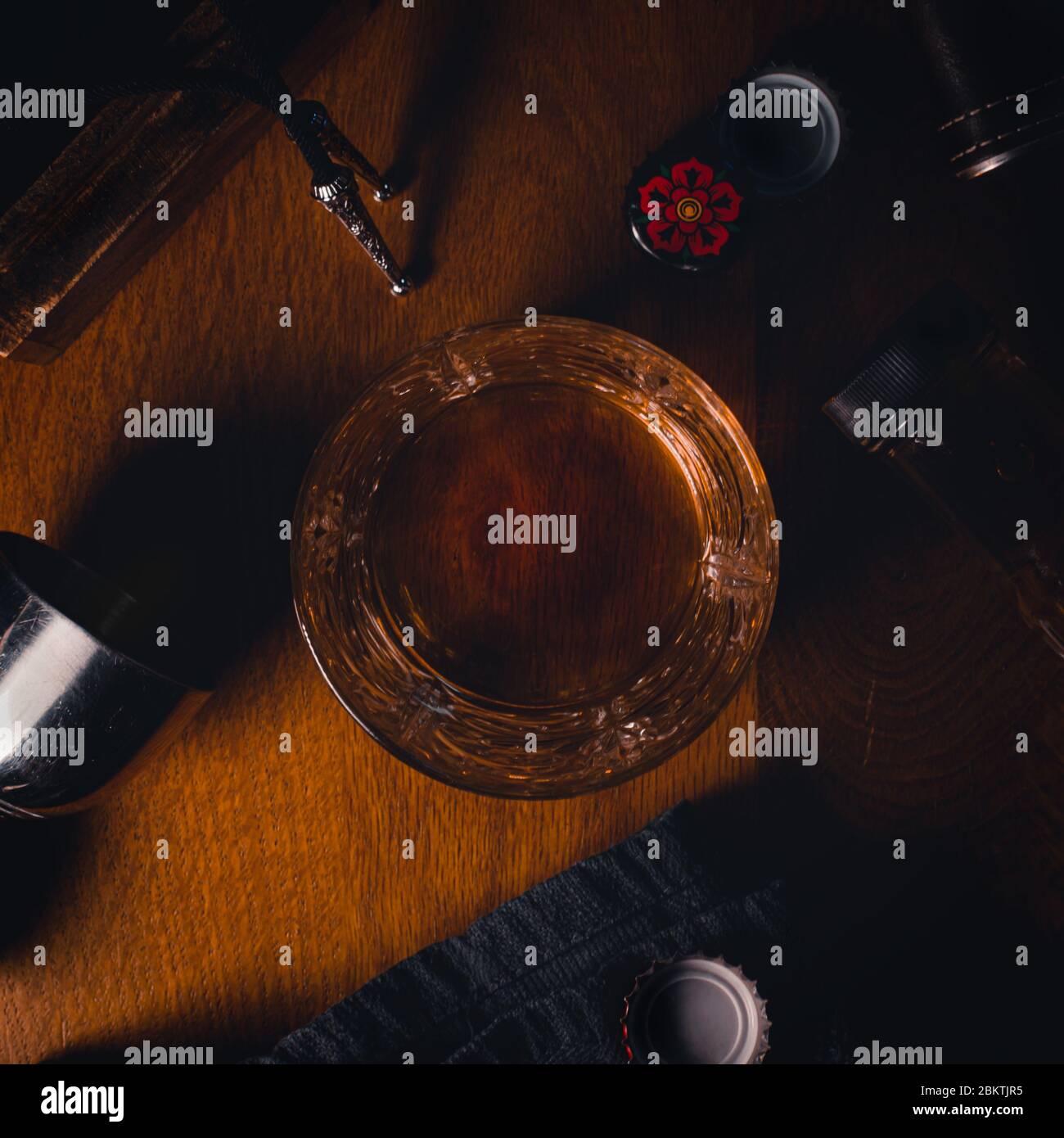 Top-down-flaches Bild von einem Glas Bourbon Whiskey umgeben von verschiedenen Accessoires Stockfoto