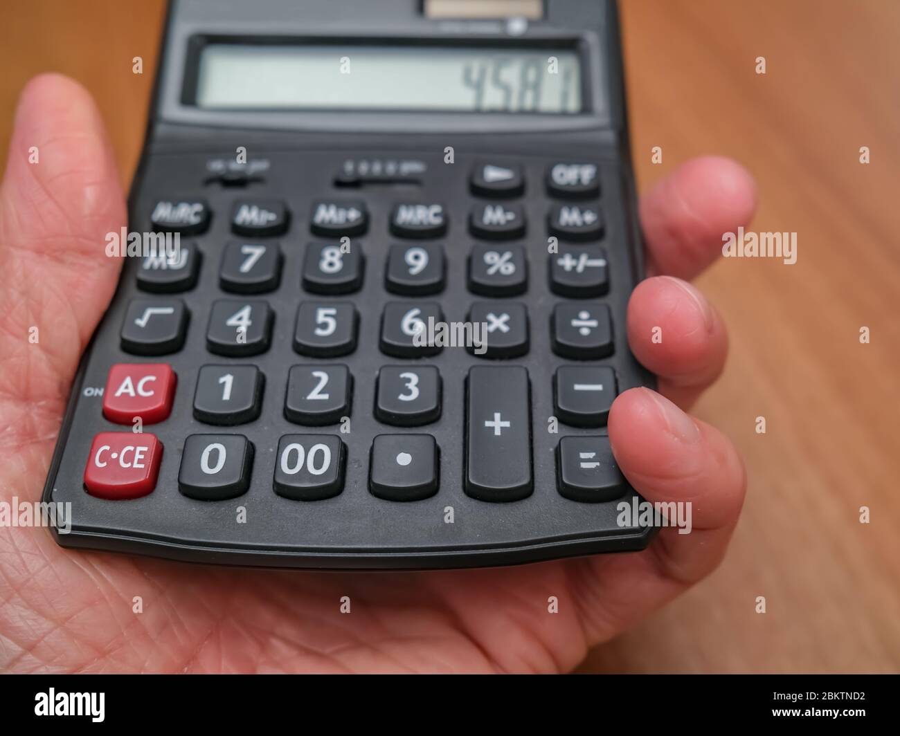 5 Nahaufnahme einer menschlichen Hand mit einem schwarzen Rechner mit selektivem Fokus und geringer Schärfentiefe Stockfoto