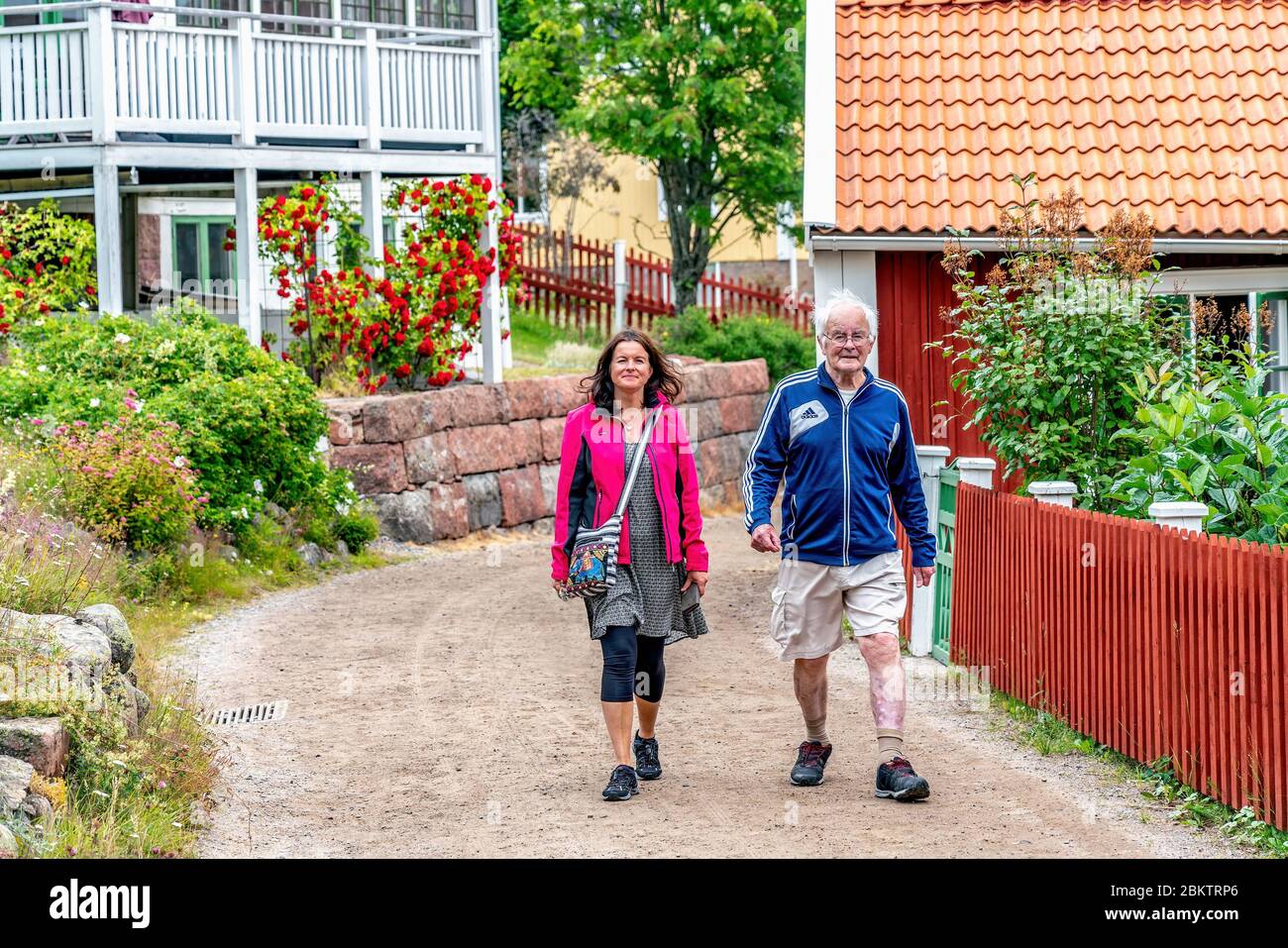 ULVON, SCHWEDEN - 23. JULI 2019: Junge skandinavische Frauen gehen mit altem Mann, Touristen wandern auf der Insel Ulvon, dem historischen Ort des Fischens in der Ostsee Stockfoto