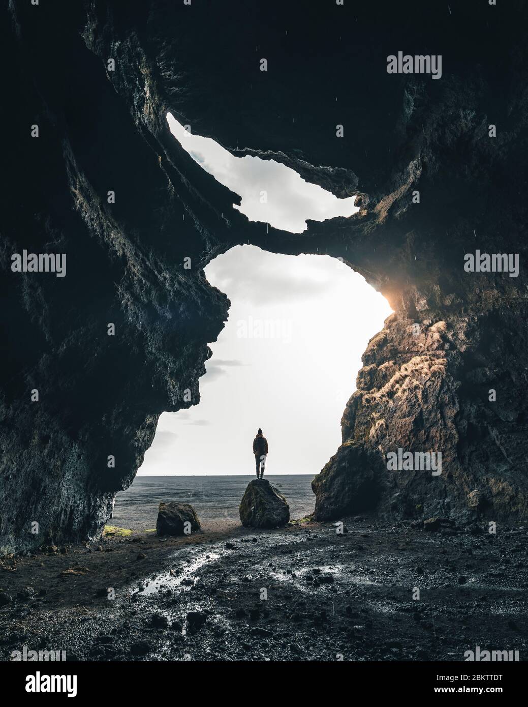 Eine Silhouette einer Person in der Höhle. Island hat sehr einzigartige Fels- und Naturformationen, die junge Abenteurer entdecken wollen Stockfoto