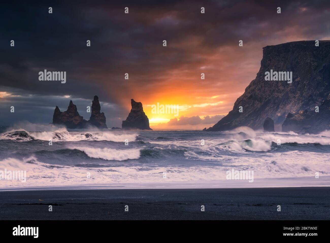 Dramatischer Sonnenuntergang Himmel über Reynisdrangar Meeresstacks und Klippe von Vik, Island Stockfoto