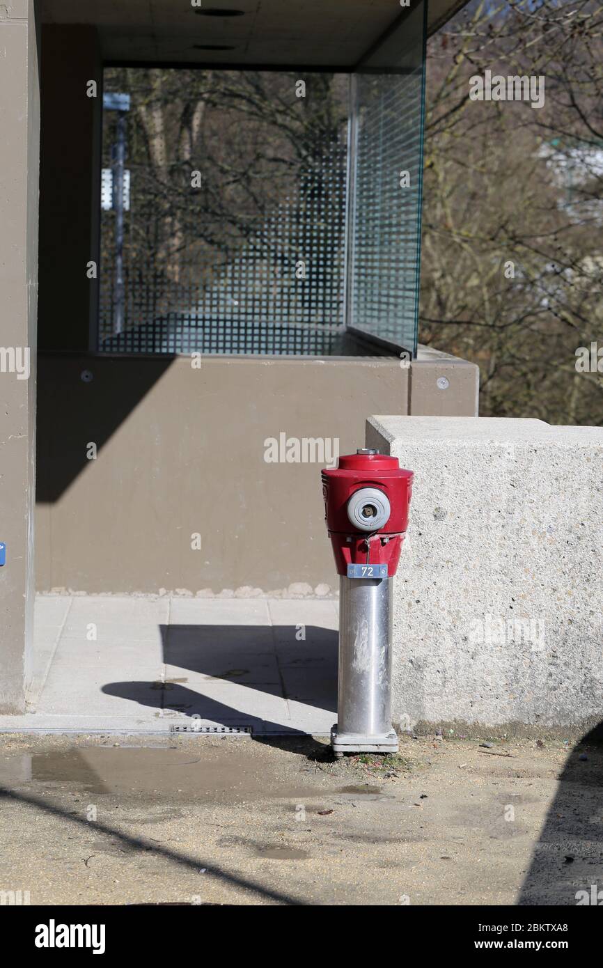 Rot-silberner Hydrant in Baden, Schweiz, März 2020. Das Porträt des Hydranten wurde während eines sonnigen Frühlingstages aufgenommen. Verwitterter Hydrant. Stockfoto