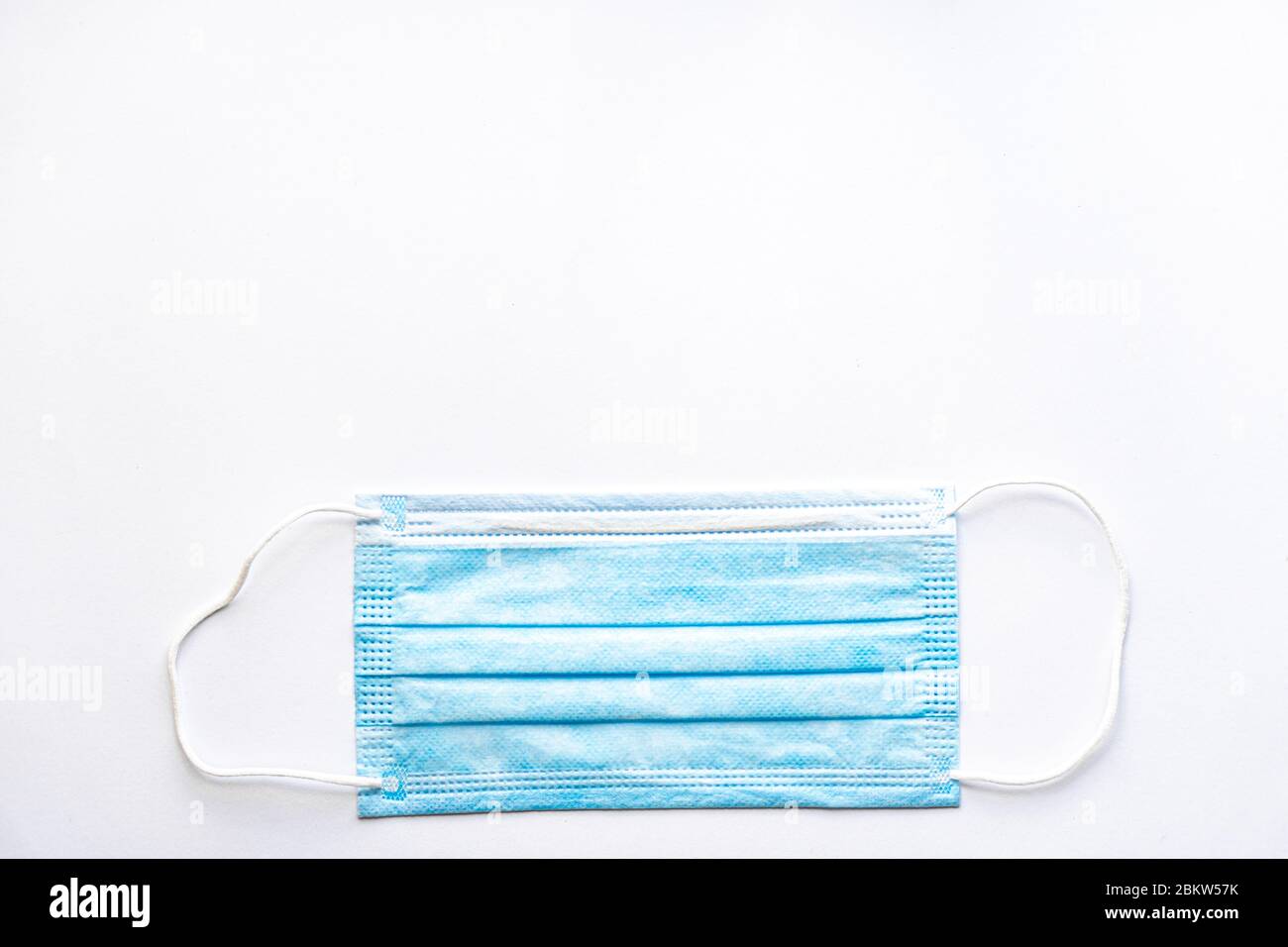 Medizinische blaue Einweg-Schutzmaske auf weißem Hintergrund kopieren Raum. Ein chirurgischer Verband schließt Mund und Nase. Gesundheitswesen, Medizin, Covid Stockfoto
