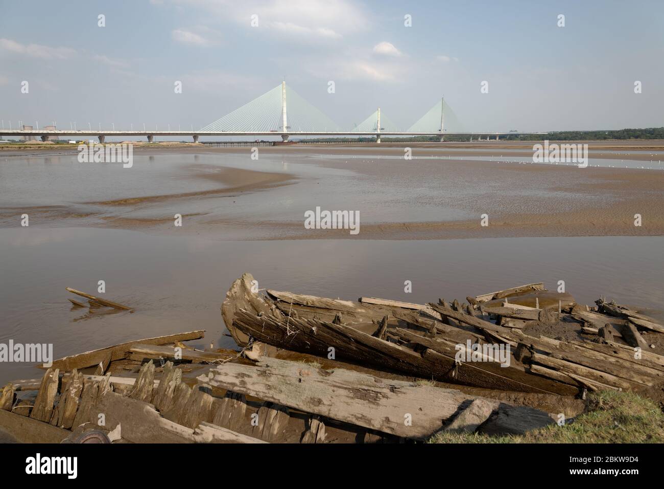 Die Überreste eines Segelkahnes, das einst auf der Mersey - einer Mersey Flat - auf Spike Island, Widnes, mit der Mersey Gateway Brücke hinter sich war Stockfoto