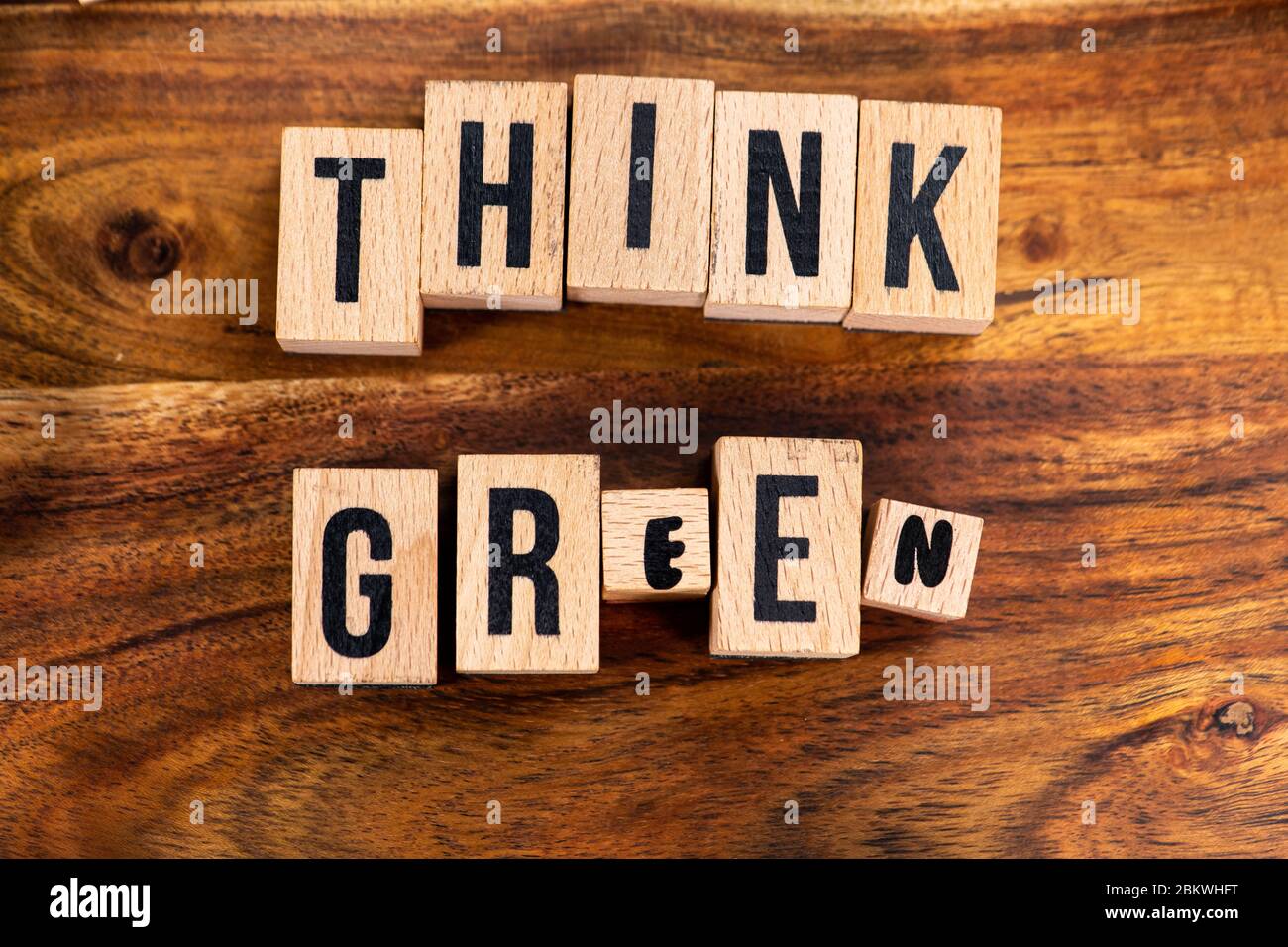 ' THINK GREEN ' Text aus Holzwürfel auf Holzhintergrund. Stockfoto
