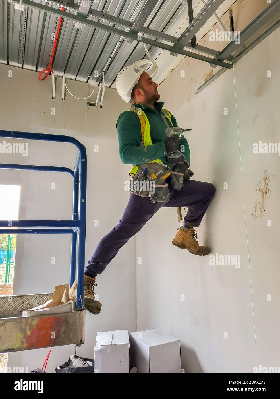 Porträt der jungen Trockenbau Auftragnehmer Installation Decke auf der Baustelle Stockfoto