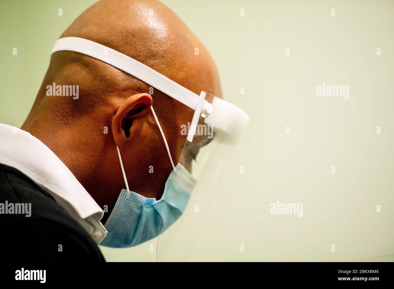 Ein Optiker, der bei der Wiedereröffnung vorsorglich einen Schutzschild und eine Maske trägt.durch Befolgung der Bedingungen der sozialen Distanzierung und Tragen einer Schutzmaske. Die niederländische Regierung erlaubte einigen Unternehmen, wieder zu öffnen. Stockfoto