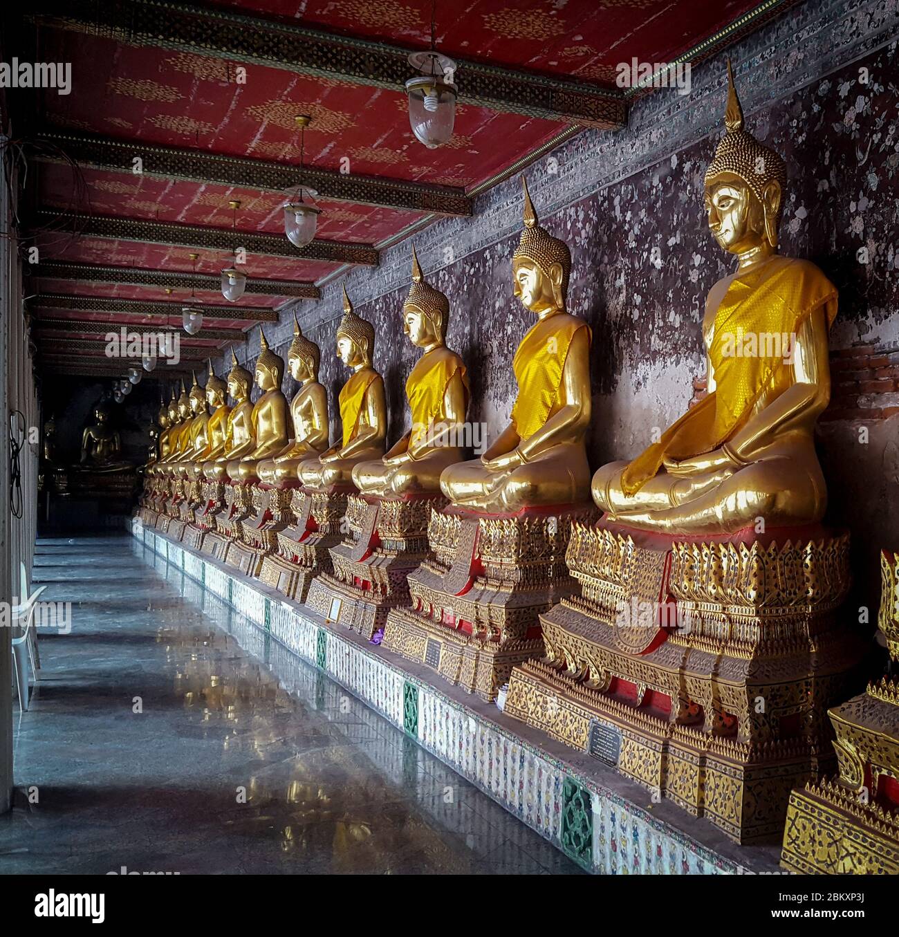 Goldene Meditationsstatuen in einer Reihe in EINEM Korridor im Wat Suthat Thepwararam Tempel Bankok, Thailand 25/11/2019 Stockfoto