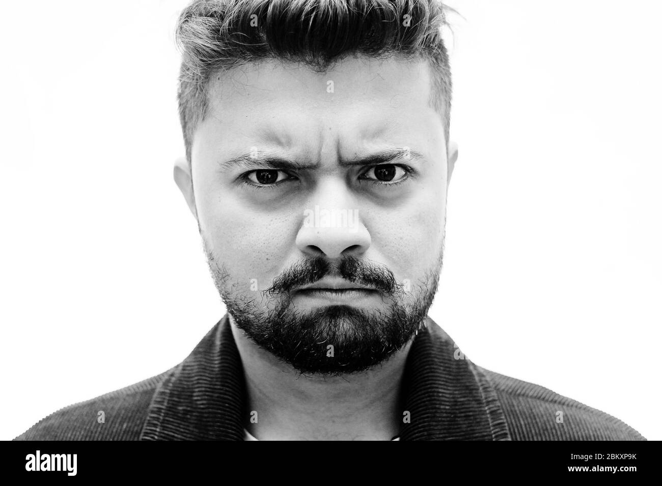 Nahaufnahme Porträt eines jungen kaukasischen Mannes wütend Gesicht Ausdruck isoliert auf weißem Hintergrund Stockfoto