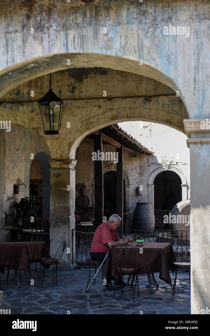 Alter Mann liest, sitzt in einer alten Tequila-Brennerei Stockfoto