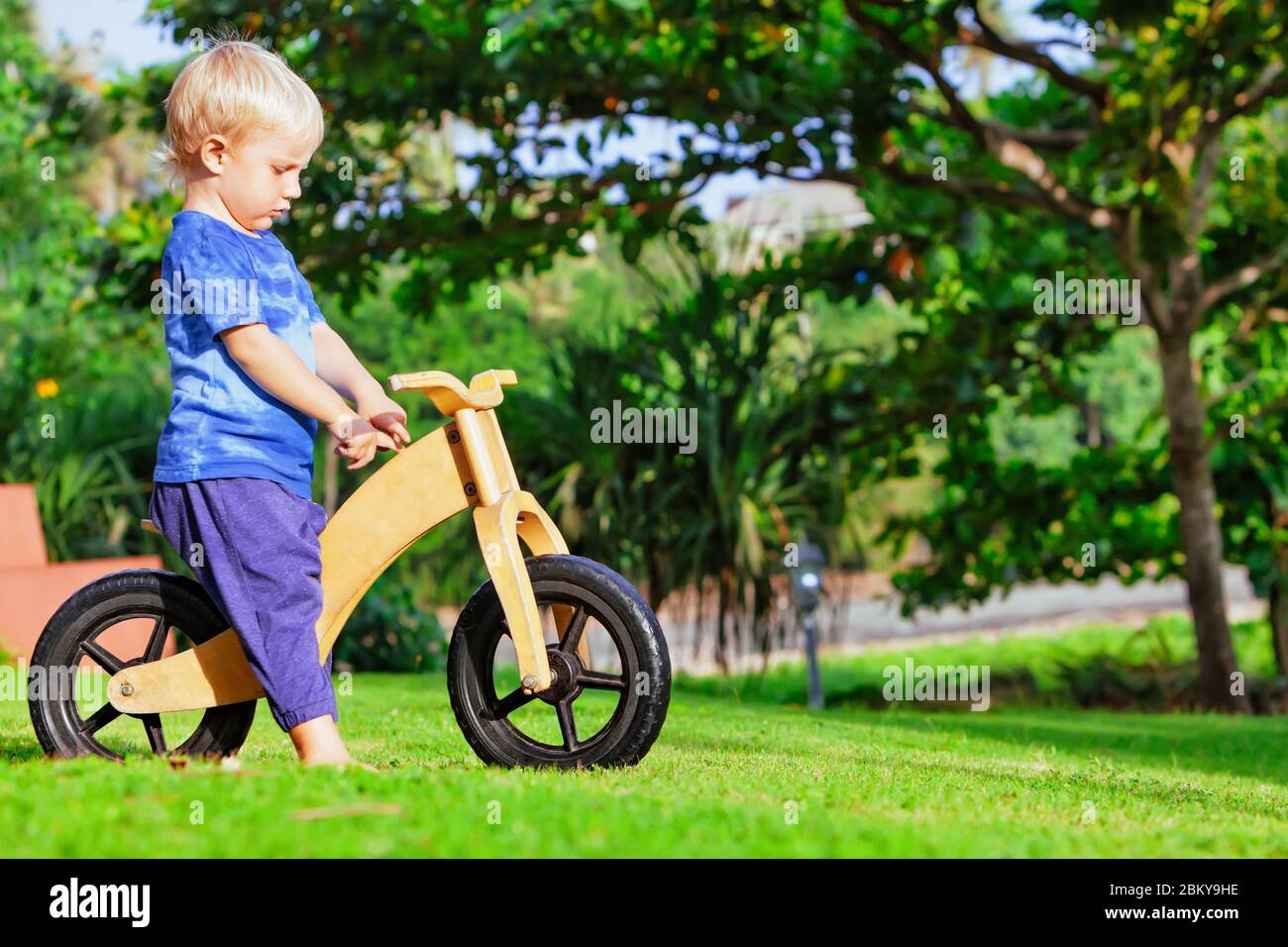 2 - 3 Jahre fröhlicher Junge mit einem Holz-Laufrad (Laufrad). Glücklich  barfuß Kind lernen, Rad, halten Gleichgewicht auf Training Fahrrad im  Garten Stockfotografie - Alamy