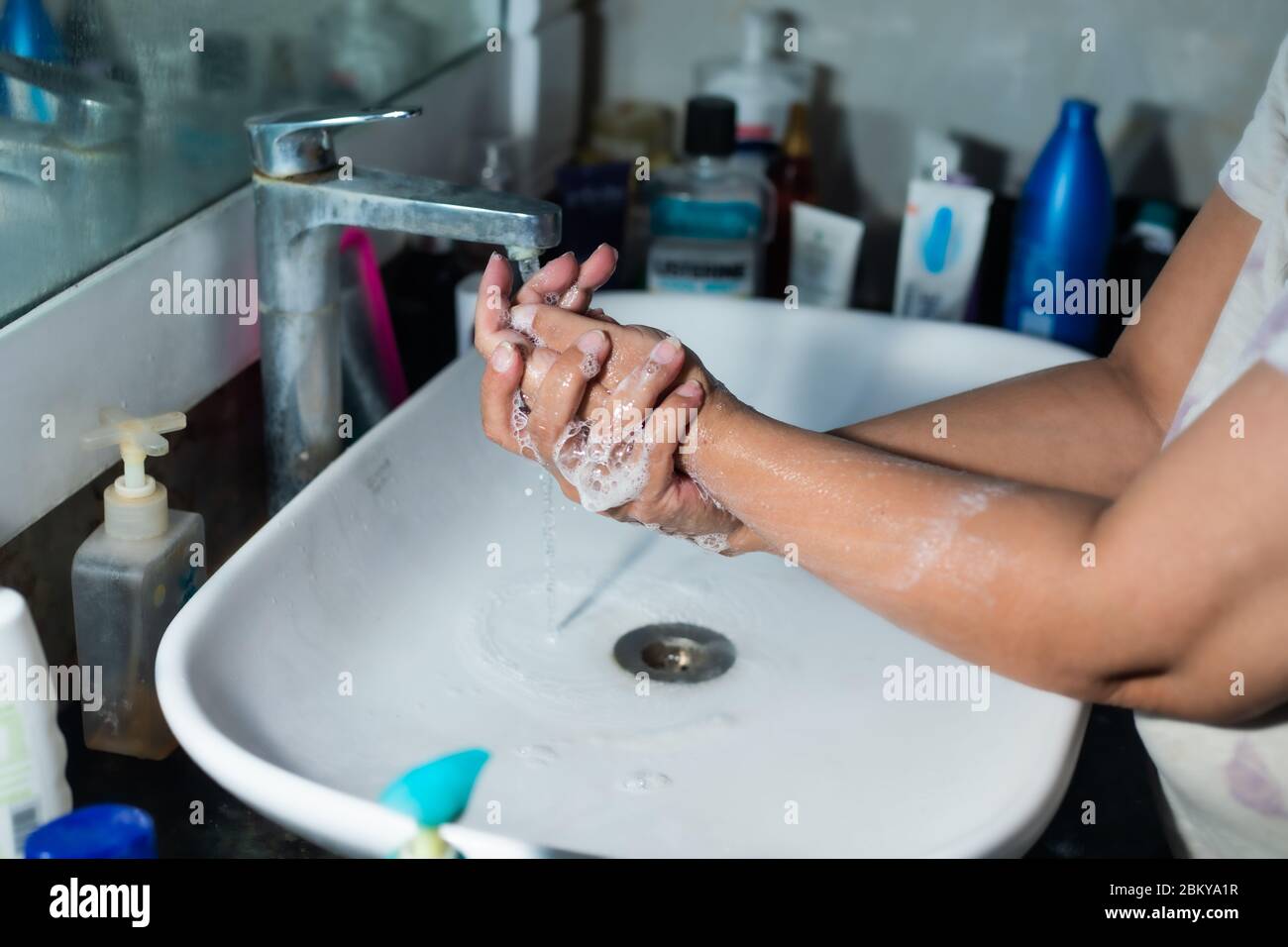 Erwachsene waschen Hände und Arme richtig mit Alkohol Seife unter dem Waschbecken/Waschbecken im Waschraum, um Coronavirus zu bekämpfen. Stockfoto