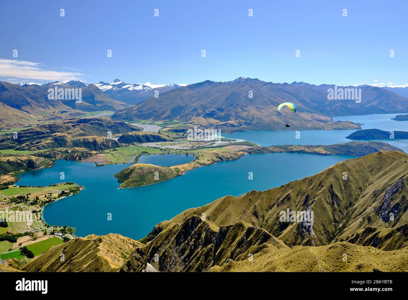 Person Paragliding über die herrliche Aussicht auf Lake Wanaka von Roy's Gipfel. Otago, Südinsel, Neuseeland. Stockfoto