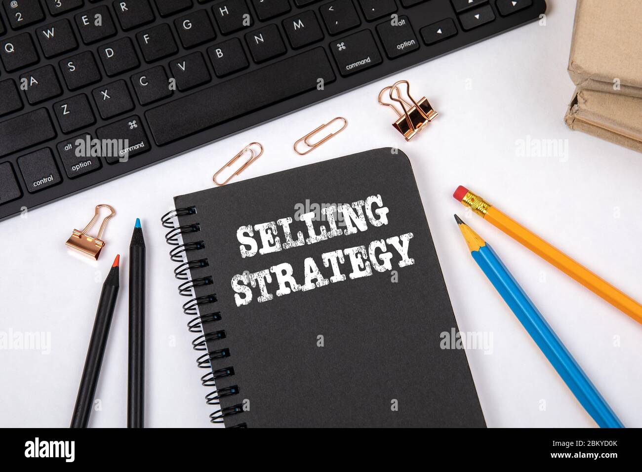 VERKAUFSSTRATEGIE. Marketing, Business, Wissen und Erfolgskonzept. Schwarzes Notebook und Computertastatur auf einem weißen Büroschreibtisch Stockfoto