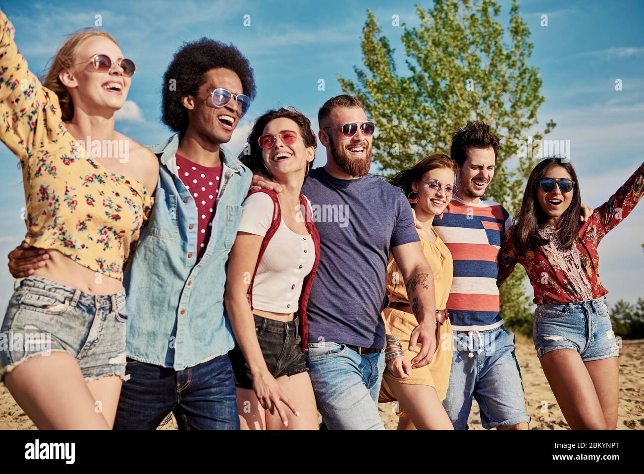 Junge lächelnde Menschen in einer Reihe an der frischen Luft Stockfoto