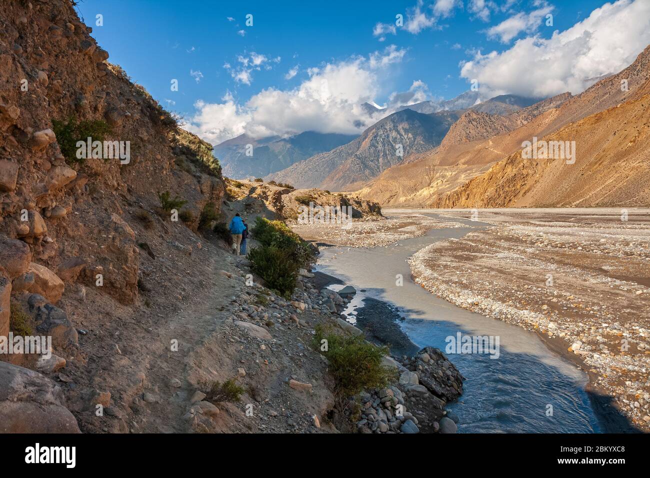 Trekking im Himalaya. Touristen mit Rucksäcken auf dem Weg entlang der Ufer des Kali Gandaki River inmitten der malerischen Himalaya-Landschaft, Lower Mustang, Stockfoto