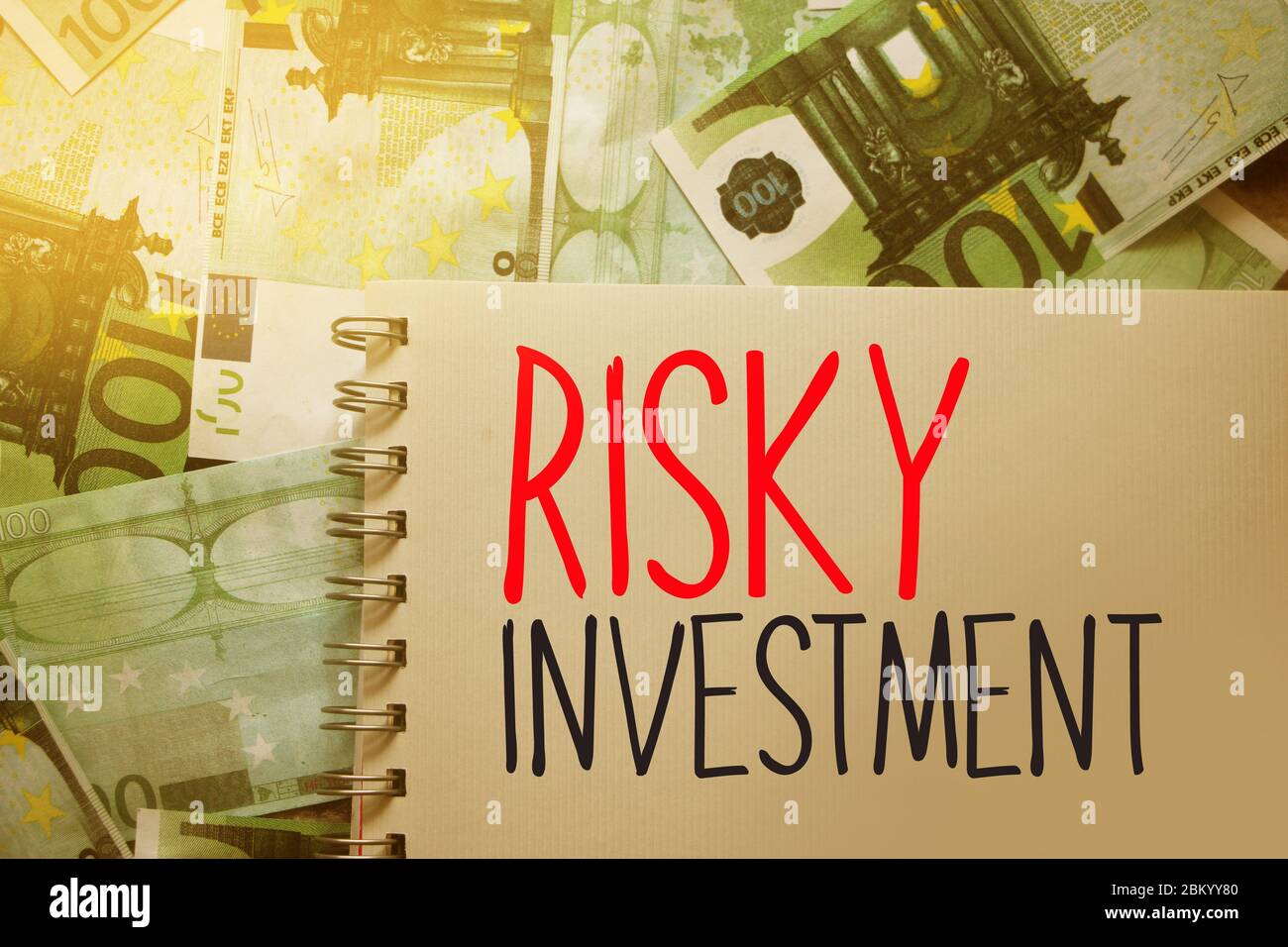 Riskante Anlageworte auf der Copybook-Seite geschrieben. Sparens und investieren finanzila Geschäftskonzept Stockfoto