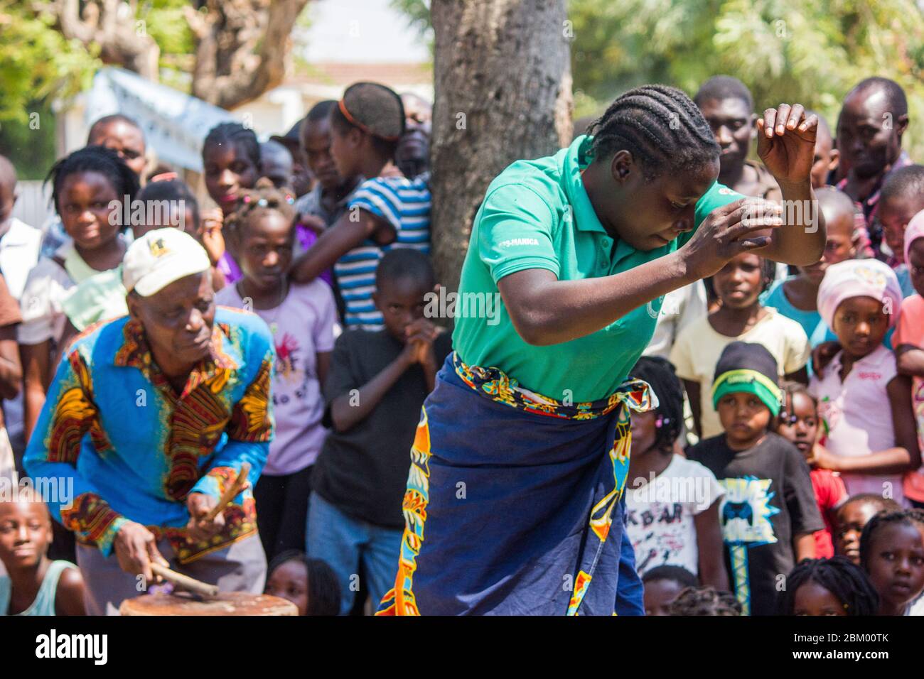 Afrikanische Frau, die im Takt eines älteren Mannes mit einer traditionellen lokalen Trommel tanzt Stockfoto