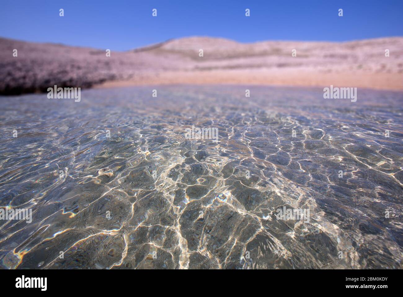 Klares Meer an einem Sandstrand Stockfoto