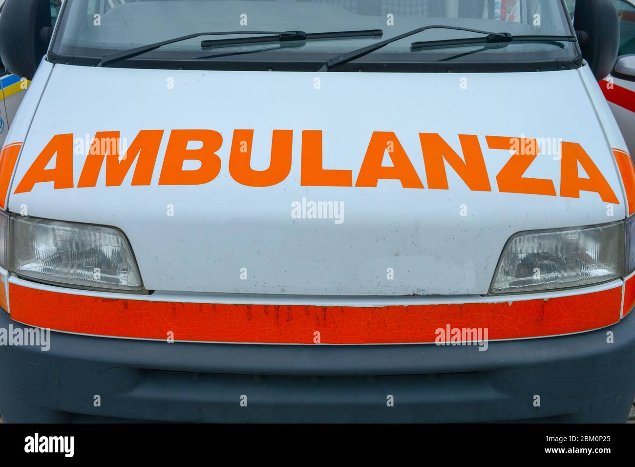 Ein italienischer Rettungswagen. Nahaufnahme eines Ambo-Fahrzeugs, das Sanitäter für Notsituationen und Patienten in Not abfährt. Orangefarbene Wörter Stockfoto