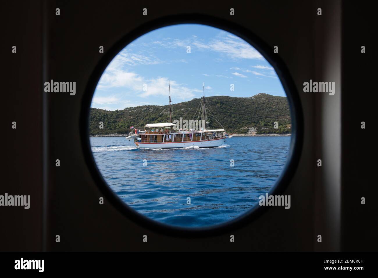 Ein hölzernes Touristenschiff, das durch eine Silhouette eines Schiffsfensters fotografiert wird Stockfoto