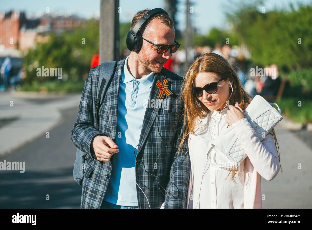 Moskau, Russland - 9. Mai 2018. Ein junger Mann mit einem St. George Band auf seinem Revers geht mit einem Mädchen im Park. Mai 9-Sieg Tag in der großen Stockfoto