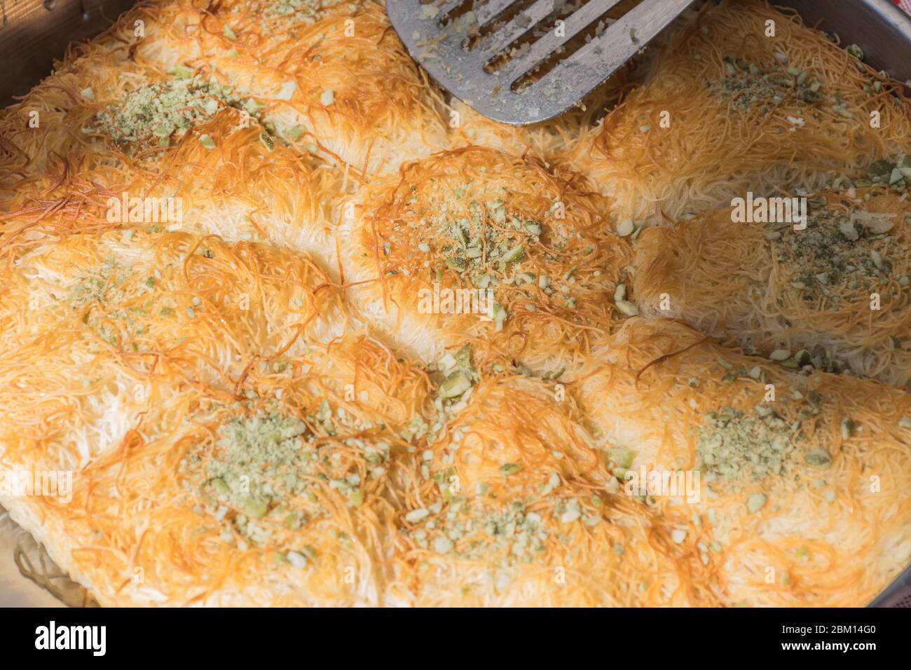 Künefe, süßes und herzhaftes levantinisches Käseteig, türkisches Dessert spezifisch und traditionell. Gebratene Kunefe aus schmelzendem hatay-Käse, der in suga beschichtet ist Stockfoto