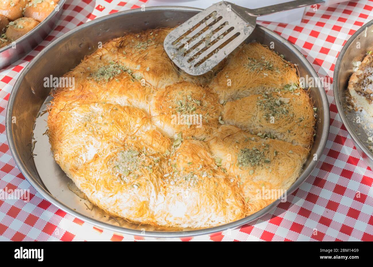Künefe, süßes und herzhaftes levantinisches Käseteig, türkisches Dessert spezifisch und traditionell. Gebratene Kunefe aus schmelzendem hatay-Käse, der in suga beschichtet ist Stockfoto