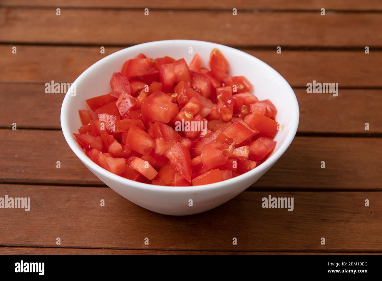 Gehackte oder gewürfelte Tomaten in einer Schüssel isoliert Stockfoto