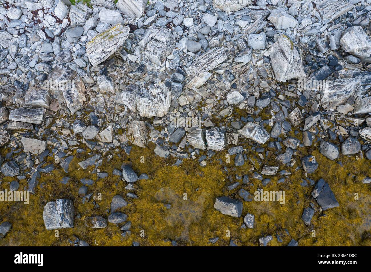 Luftaufnahme von oben auf die Wellen, die auf die Felsen am Strand treffen. Stockfoto