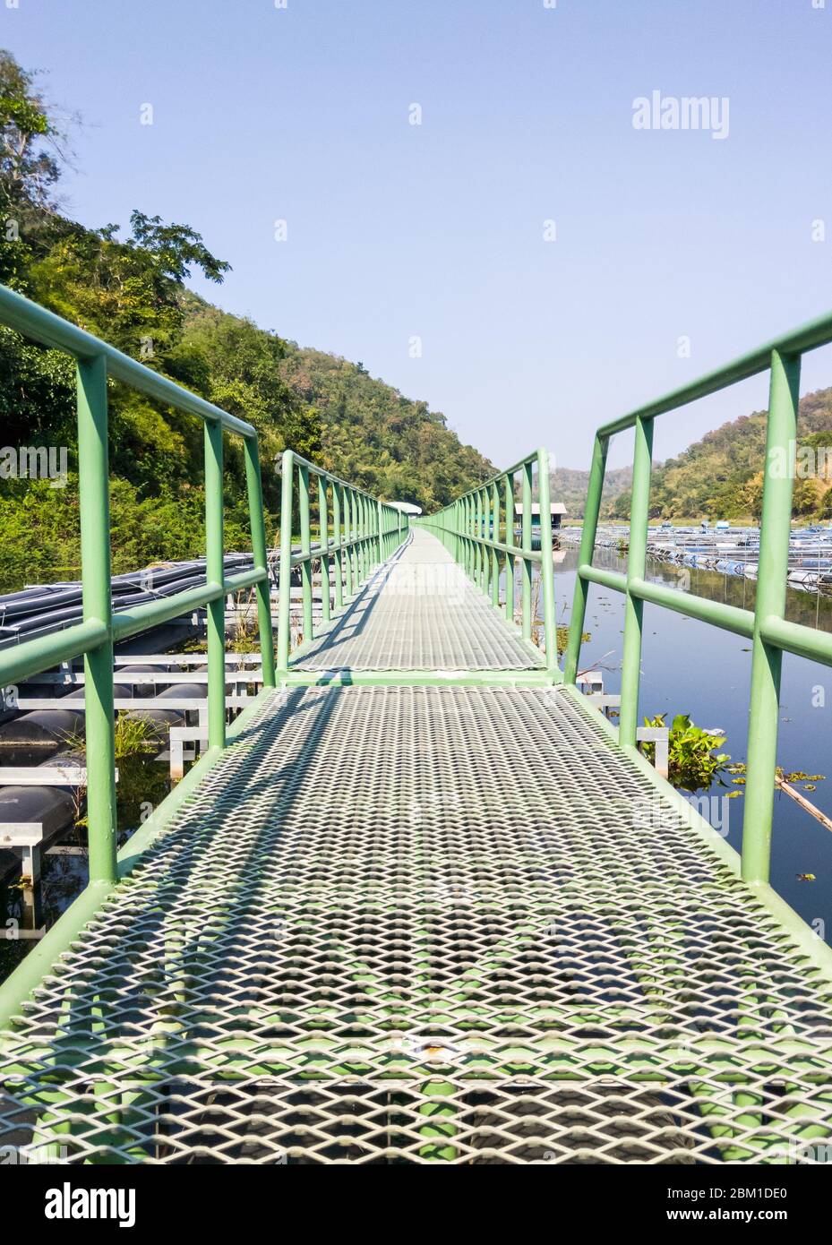 Lange Metallbrücke schwimmt auf dem Stausee für den Einsatz, um zur Wasserpumpstation zu gehen, für Wasserwerke in der ländlichen Umgebung. Stockfoto