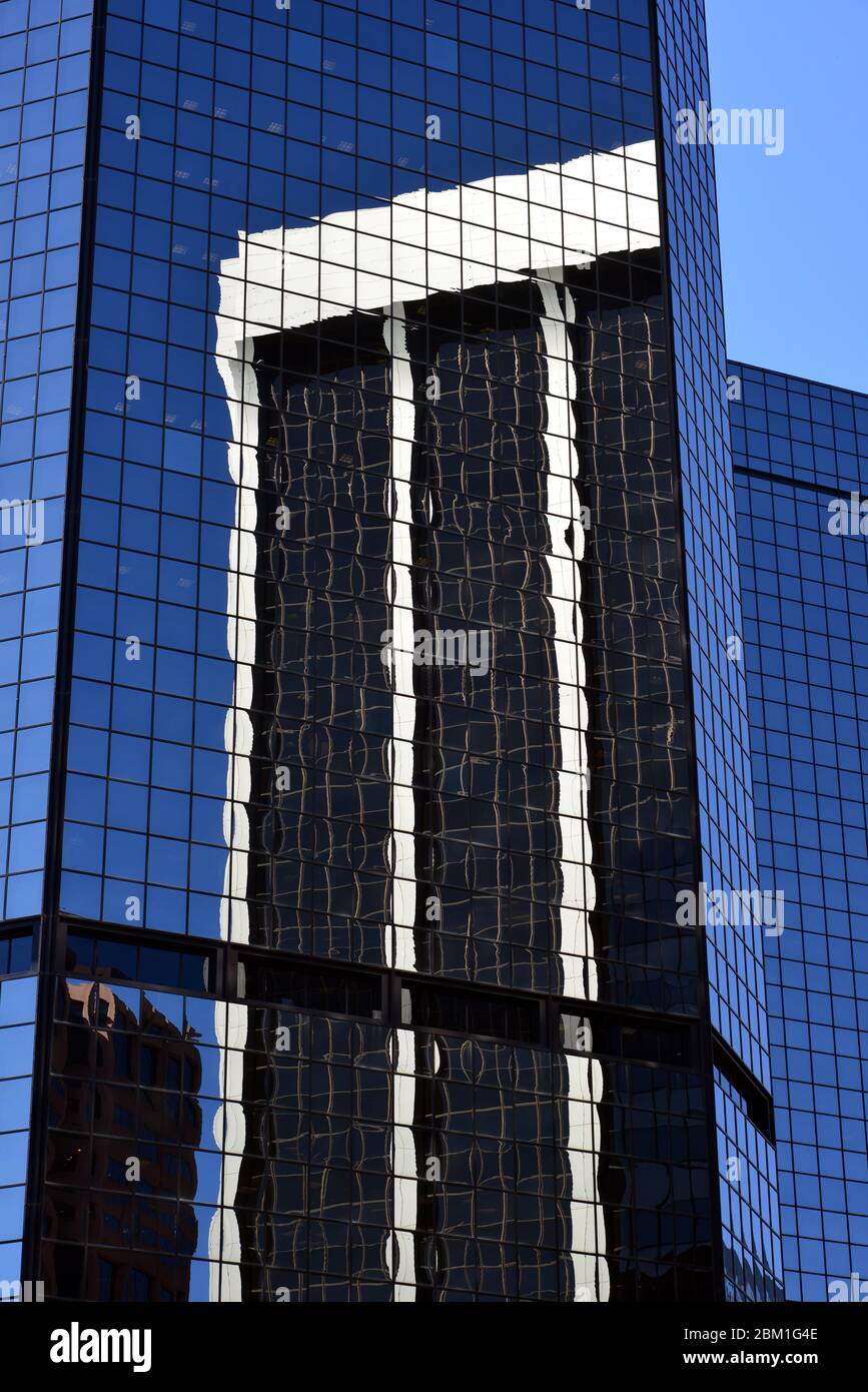 Ein Wolkenkratzer spiegelte sich an einem sonnigen Tag im Juni in Denver, Colorado, in einem anderen wider Stockfoto