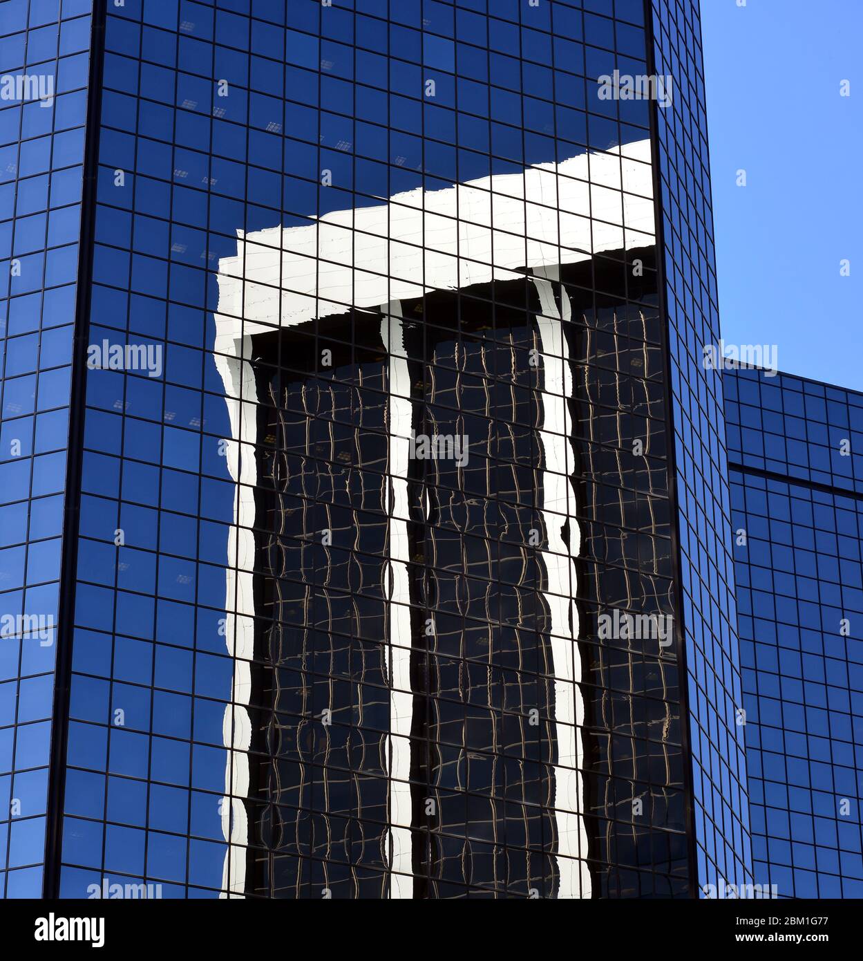 Ein Wolkenkratzer spiegelte sich an einem sonnigen Tag im Juni in Denver, Colorado, in einem anderen wider Stockfoto