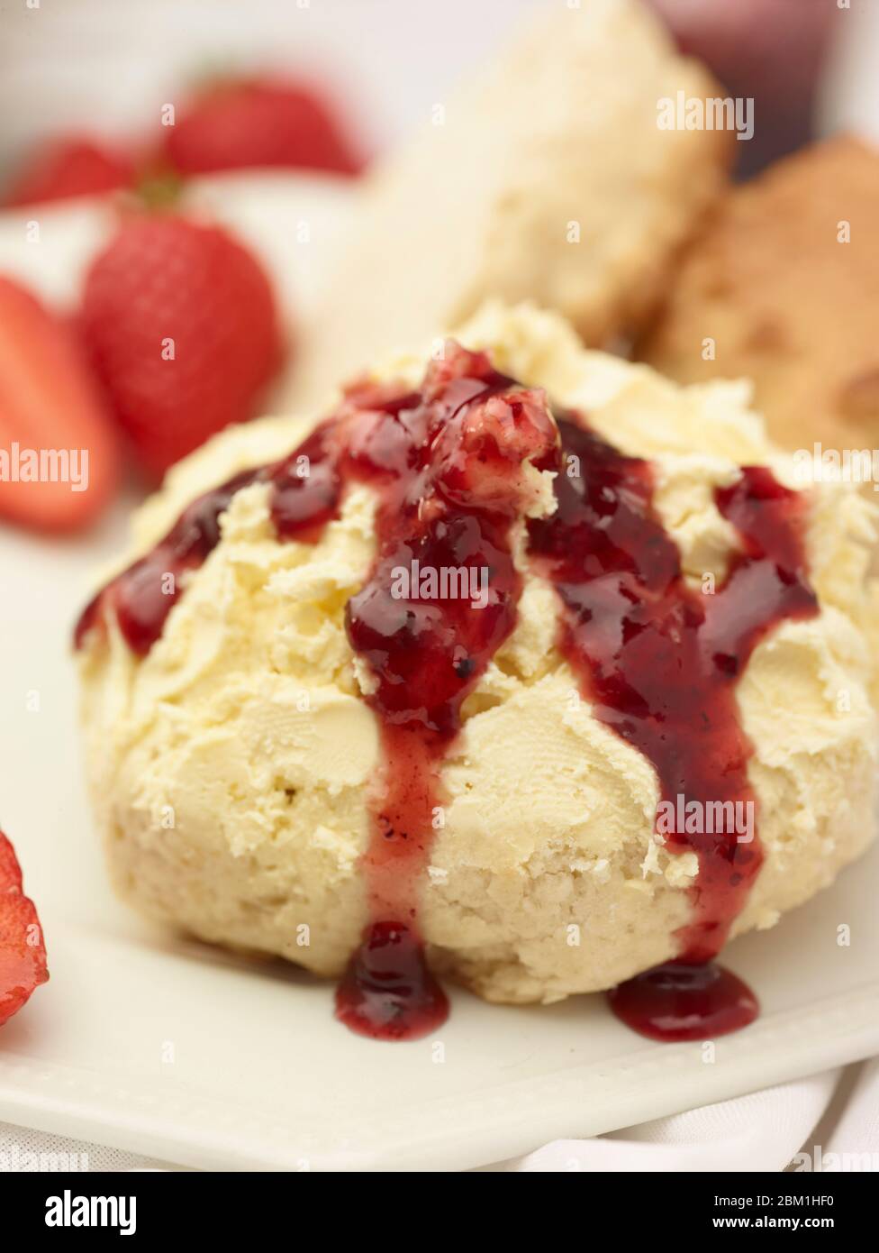 Britischer Sahnetee, Scones mit gerinnter Sahne, Erdbeermarmelade und Erdbeeren auf weißem Hintergrund, Food Stillleben Stockfoto