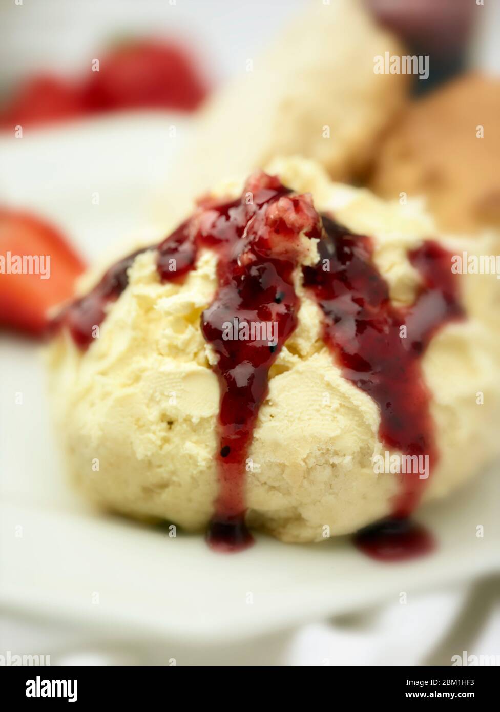 Britischer Sahnetee, Scones mit gerinnter Sahne, Erdbeermarmelade und Erdbeeren auf weißem Hintergrund, Food Stillleben Stockfoto