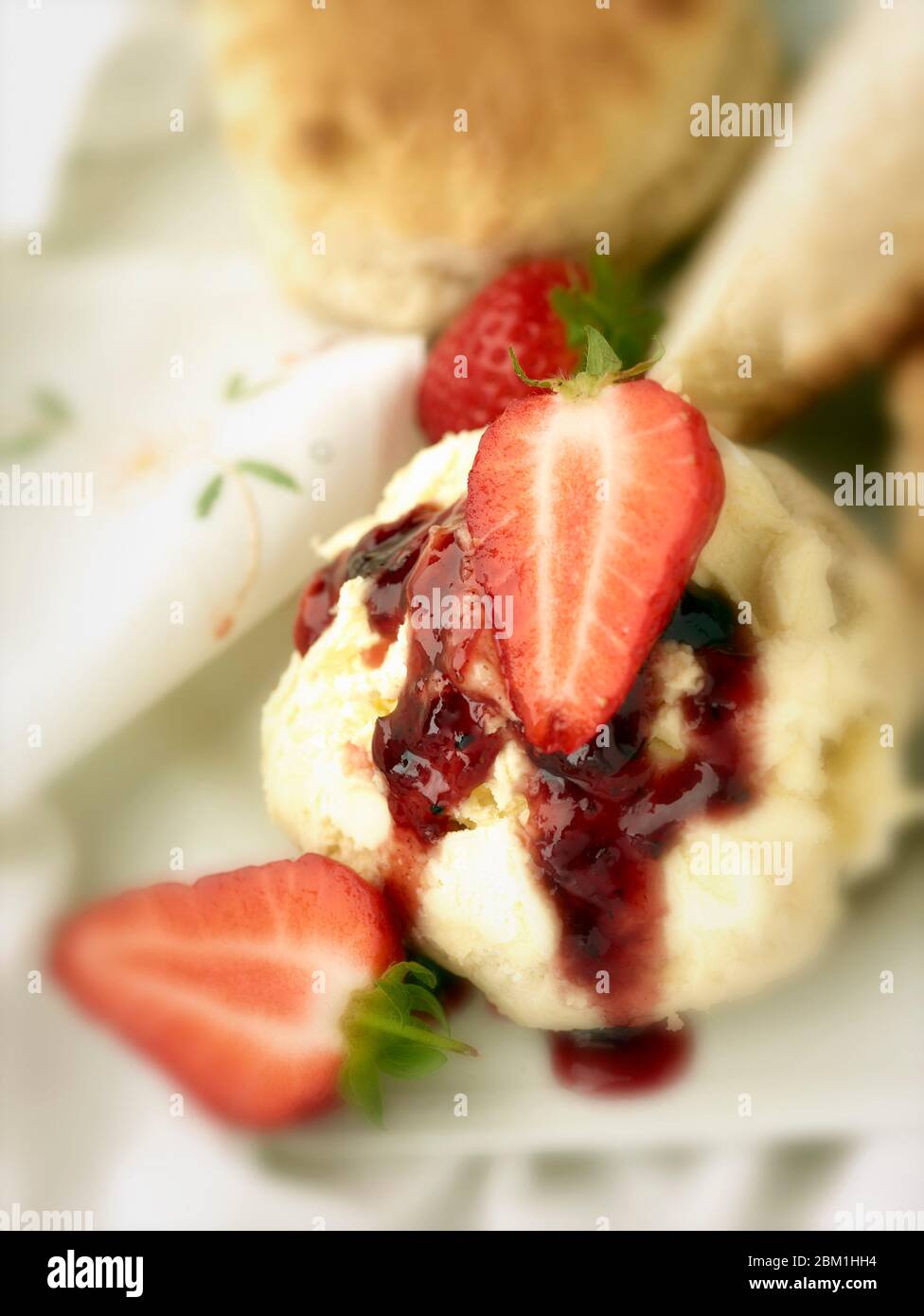 Britischer Sahnetee, Scones mit gerinnter Sahne, Erdbeermarmelade und Erdbeeren auf weißem Hintergrund, Food Stillleben Stockfoto