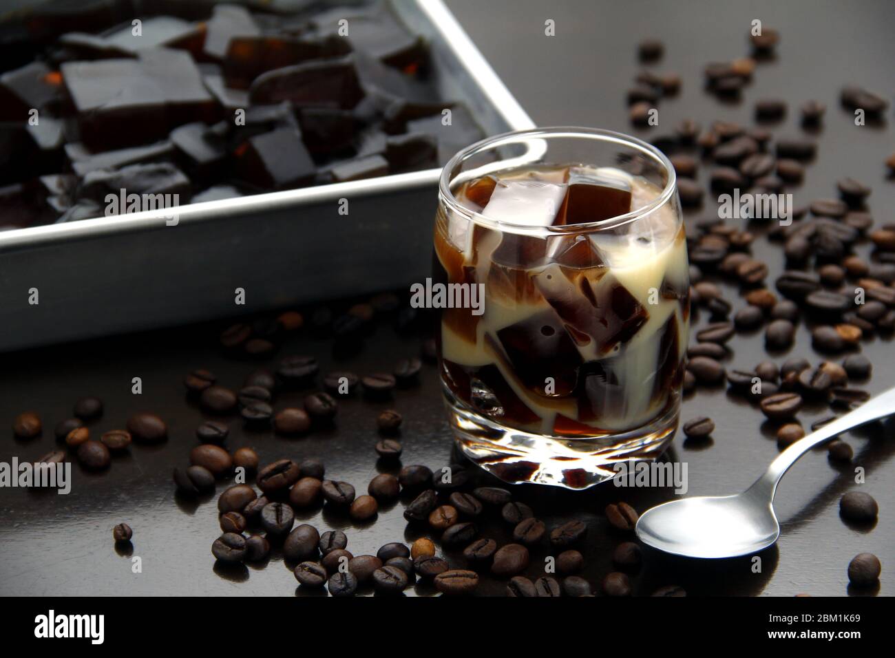 Foto von Kaffee gewürzt Gelee mit Milch in einem klaren Glas auf einem Tisch. Stockfoto