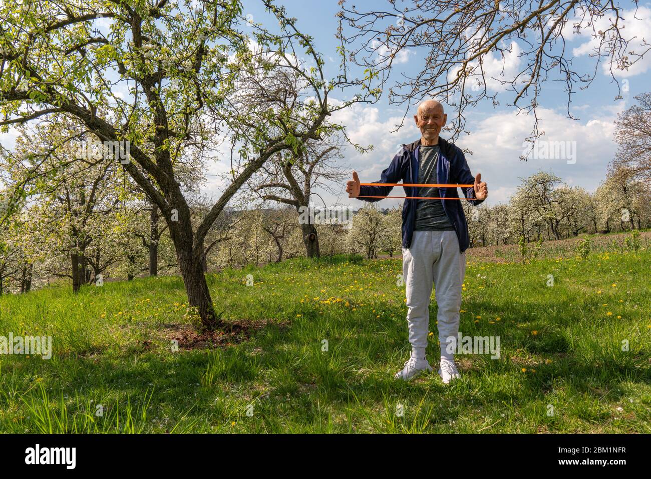 Alter europäischer Mann Stretching seine Muskeln in Konzept des Trainings zu Hause mit Widerstand Band. Stockfoto